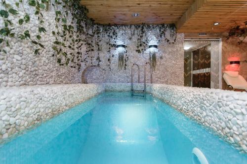a swimming pool in a room with a stone wall at Boutique Hotel California in Odesa