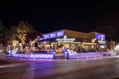 a store with blue lights in front of it at night at Stratovarius Nissi Rooms in Ayia Napa