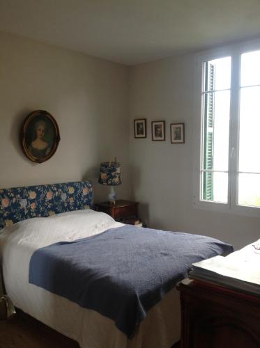 une chambre avec un lit avec une couverture bleue et une fenêtre dans l'établissement Appartement Tout Confort avec Terrasse, à Nice