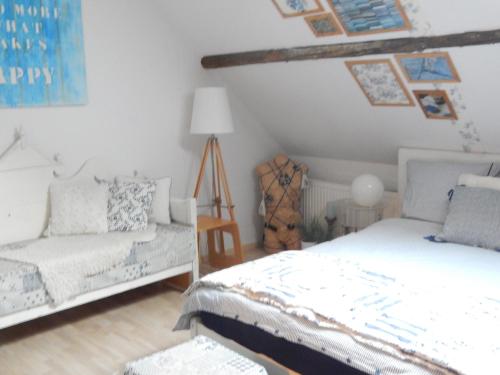 1 dormitorio con 2 camas y sofá en Tintaglia, betaalbaar en gastvrij, en Stadskanaal