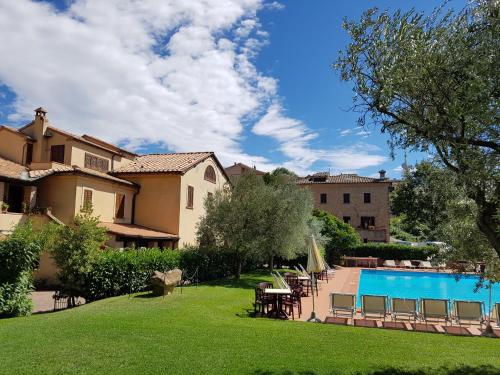 a large yard with a swimming pool and a house at Villa Nencini in Volterra