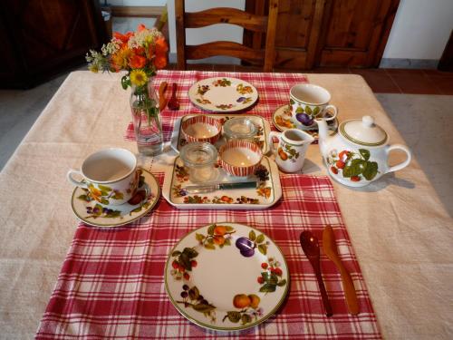 stół z talerzami i kubkami na czerwonej tkaninie w obiekcie Galleria Ars Apua w mieście Carrara