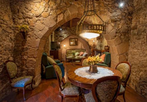 a room with a table and chairs in a stone wall at Cal Calaf in Vilardida
