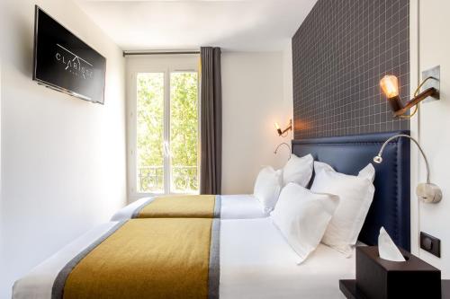 Ένα ή περισσότερα κρεβάτια σε δωμάτιο στο Hôtel Clarisse