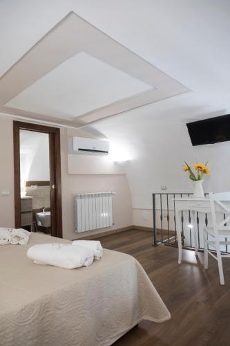 a white room with a bed and a table and a window at TRA... INCANTO E NATURA in Tramonti