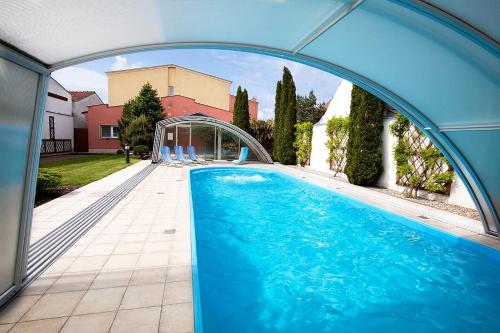 a large swimming pool with an arch over it at Hotel Akademie a depandance Vila Jarmila in Velké Bílovice