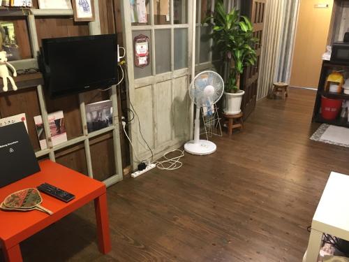 a living room with a fan and a television at Guest house AmaMin in Amami