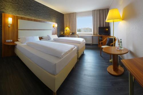 ein Hotelzimmer mit 2 Betten und einem TV in der Unterkunft Best Western Plaza Hotel Zwickau in Zwickau
