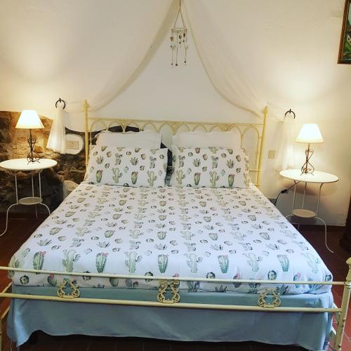 a bed in a bedroom with two tables at La Mariola Apartments in Santa Luce