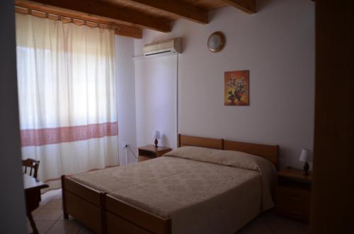 1 dormitorio con cama y ventana en Agriturismo Agrifoglio en San Giovanni Suèrgiu