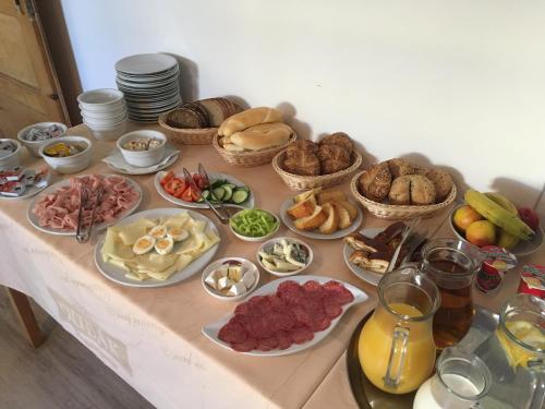 Una mesa con muchos tipos diferentes de comida sobre ella. en Penzion Sole Bučovice, en Bučovice