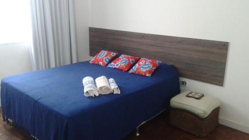 um quarto com uma cama azul e 2 toalhas em Luiz & Cristiana Sampaio em Salvador