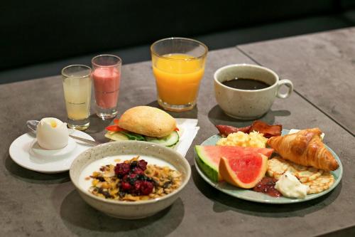 a table topped with plates of breakfast food and drinks at First Hotel Brommaplan in Stockholm