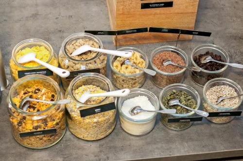 a bunch of glass jars filled with different types of food at First Hotel Brommaplan in Stockholm