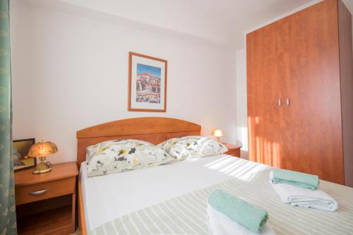 a bedroom with a bed with two towels on it at Katarina apartmani in Podstrana