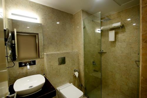 a bathroom with a shower and a sink and a toilet at Imperial Heights in Deoghar