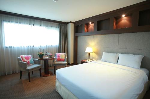 a hotel room with a large bed and two lamps at Incheon Airport Hotel Zeumes in Incheon