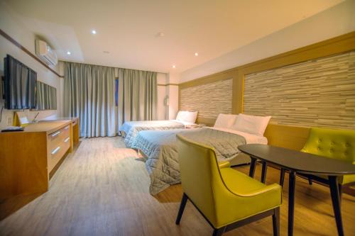 Cette chambre comprend un lit, un bureau et une table. dans l'établissement Incheon Airport Hotel Zeumes, à Incheon