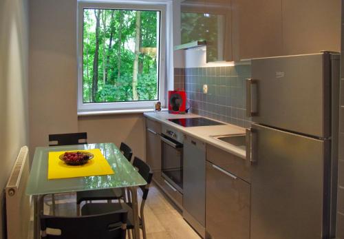 eine kleine Küche mit einem Tisch und einem Kühlschrank in der Unterkunft Sopocki Dworek in Sopot