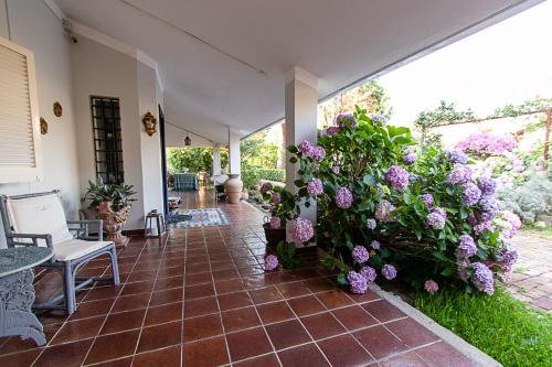 a porch with a bunch of purple flowers at Villa Hermes in San Ferdinando