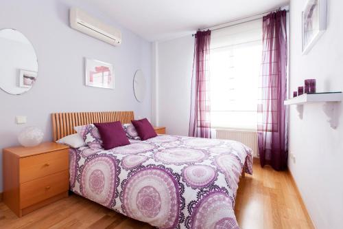 - une chambre avec un lit et une couette violette dans l'établissement ARGANZUELA, à Madrid