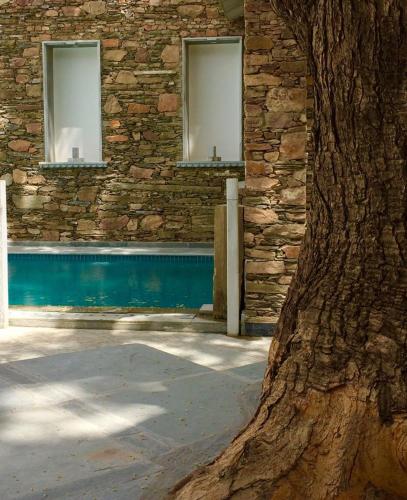 a stone building with two windows and a tree at The Neem Tree in Udaipur