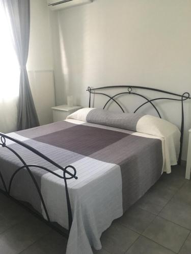 a bed with a white bedspread and pillows at Aeroporto Bellini Rooms in Catania