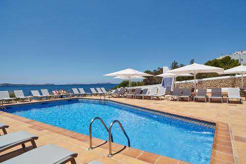 
a beach with a pool and chairs and a pool table at Sol Bahía Ibiza Suites in San Antonio
