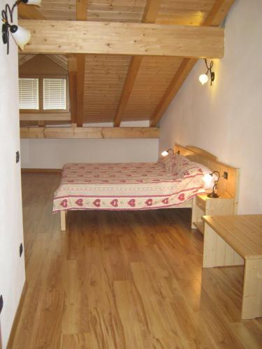 a bedroom with a bed and a wooden floor at Agriturismo Pisani in Brez