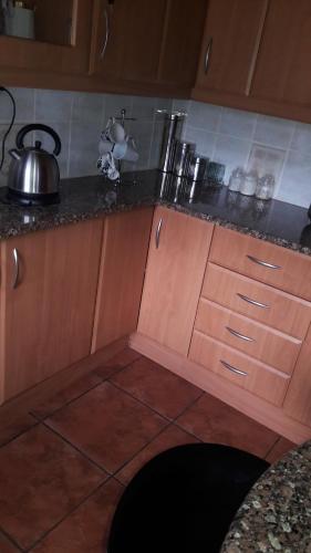 a kitchen with wooden cabinets and a tea kettle on the counter at Tehilah in Sabie