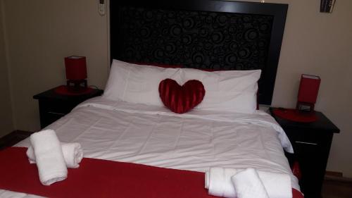a bed with a red heart pillow on it at Tehilah in Sabie