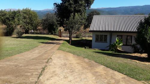 a small house with a road next to a yard at Tehilah in Sabie