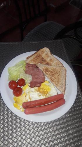 a plate of food with a breakfast sandwich and toast at Tehilah in Sabie