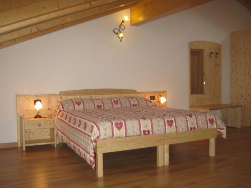 a bedroom with a large bed with a wooden headboard at Agriturismo Pisani in Brez