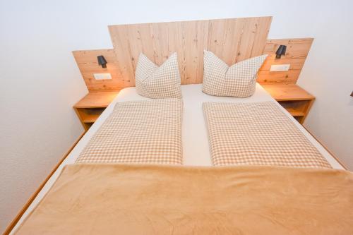 a bed with two pillows on it in a room at Haus Notburga in Serfaus