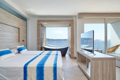 
a hotel room with two beds and a window at Sol Bahía Ibiza Suites in San Antonio
