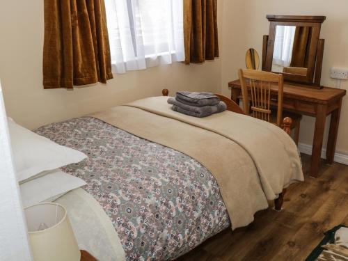 a bedroom with a bed and a desk and a window at Killary Bay View House in Renvyle