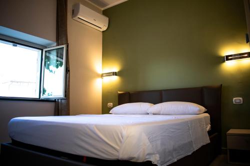 a bedroom with a bed with two pillows and a window at B&B L'Uliveto in Marina di Schiavonea