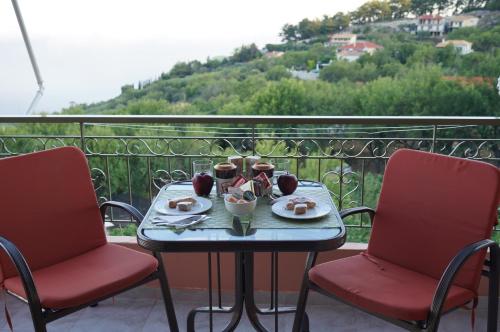 a table with food and two chairs on a balcony at Nontas Homes in Kalamitsi