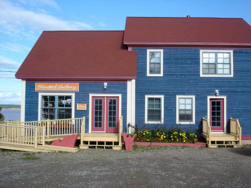 une maison bleue avec des fleurs devant elle dans l'établissement The Artisan Suites, à Hopewell Cape