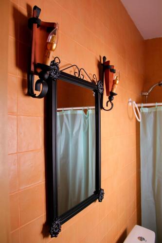 a mirror in a bathroom with lights on the wall at Alojamiento Buena Vista in Alcalá del Júcar