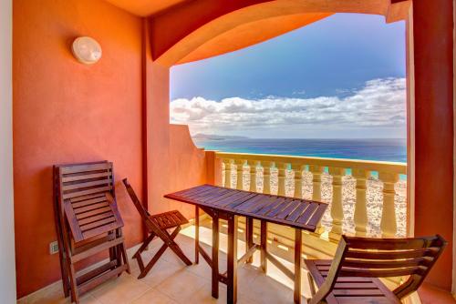 a balcony with a table and chairs and the ocean at Your Ocean Window in Costa Calma