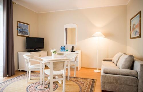 a living room with a table and a couch at Hotel Renusz in Gdańsk