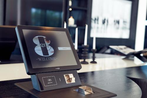 a computer monitor sitting on a desk on a table at Gr8 Hotel Oosterhout in Oosterhout