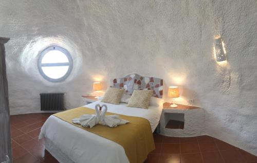een slaapkamer met een bed in een kamer met een raam bij Hotel Rural los Caracoles in Frigiliana