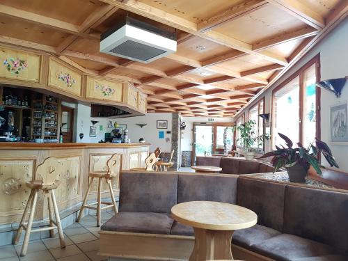 un restaurant avec un bar doté de bancs et d'une table dans l'établissement Hôtel La Vanoise, à Bessans