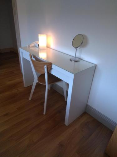 a white desk with a chair and a mirror at Burren Rock Farmhouse B&B in Turlough