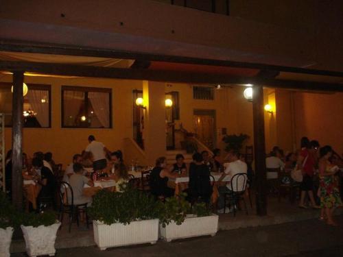a group of people sitting at tables in a restaurant at Un posto al sole in Torretta