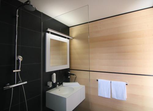 a bathroom with a white sink and a mirror at LH Hotel by WMM Hotels in Leipheim