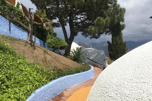 a walkway leading up to a house with trees at Hotel Rural los Caracoles in Frigiliana